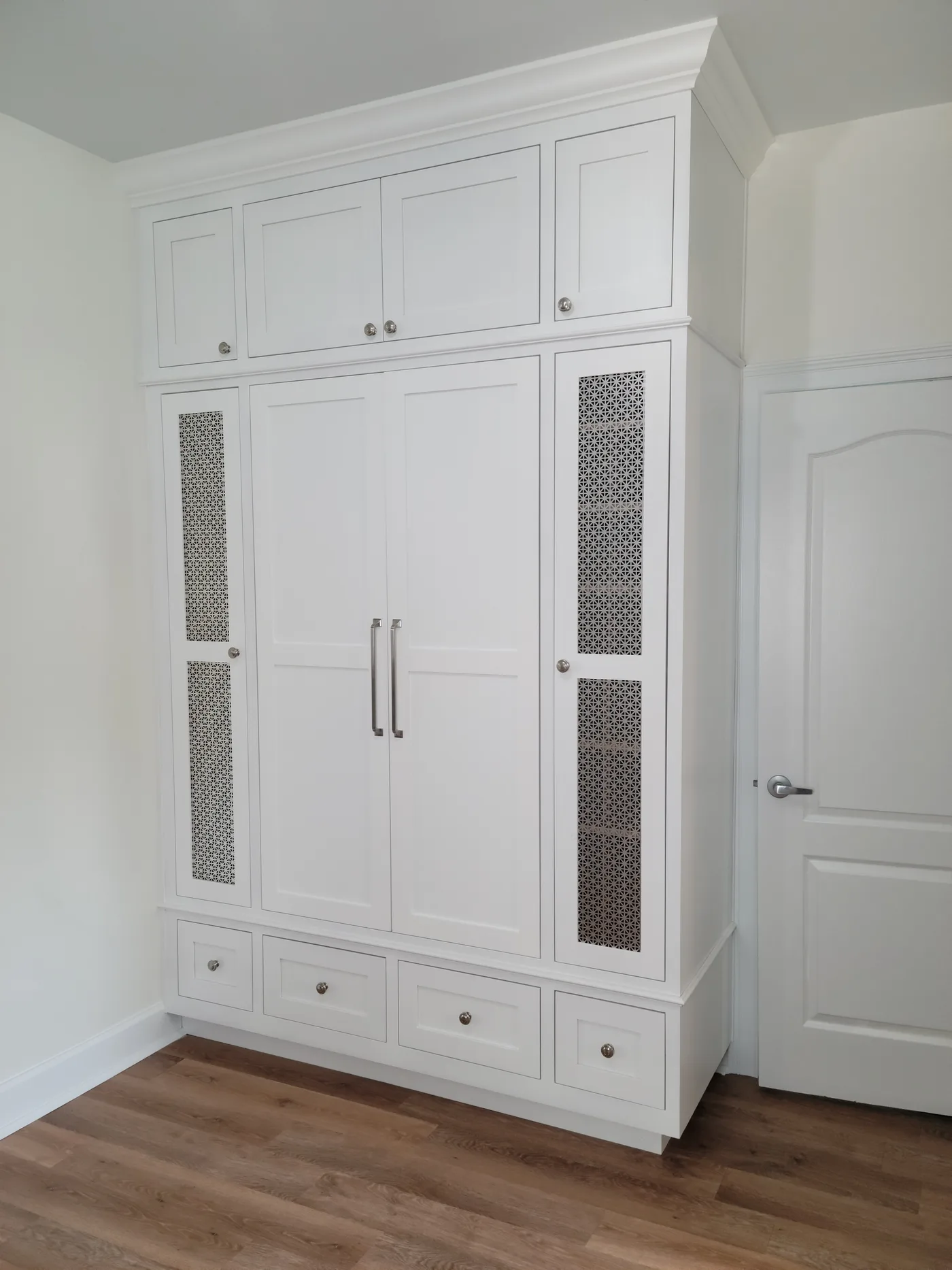 Tall white storage cabinet with cane-panel inserts