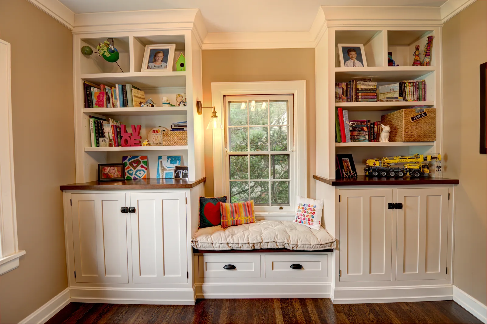 White custom built-in bookcases flanking a cushioned window seat