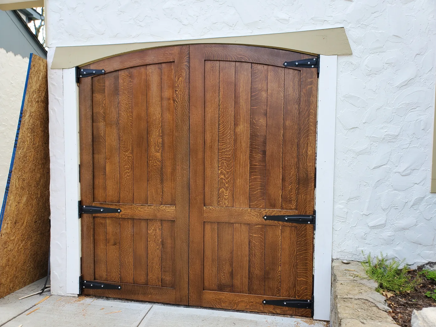 Arched stained-oak entry doors with strap hardware