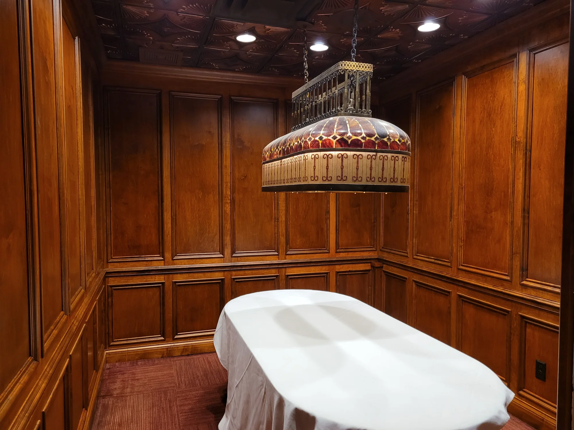 Hand-crafted walnut raised-panel room with a carved coffered ceiling by Wildwater Custom Cabinetry