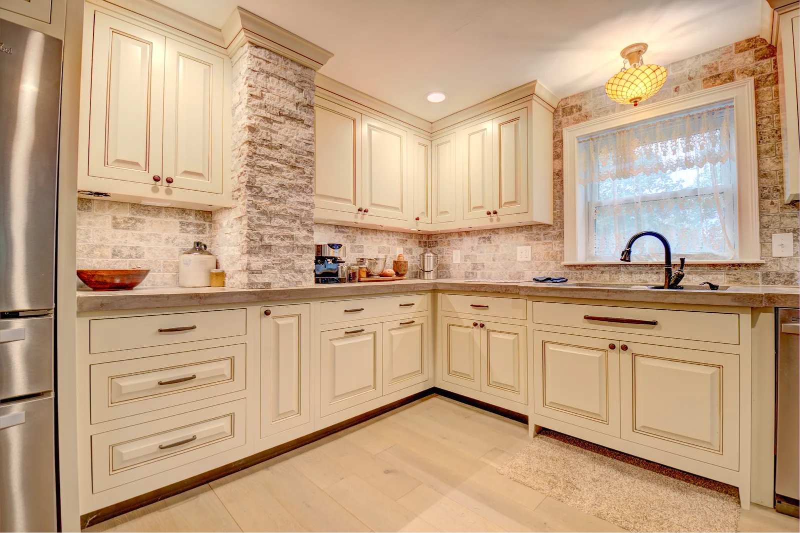 Cream antique-glazed kitchen with brick backsplash