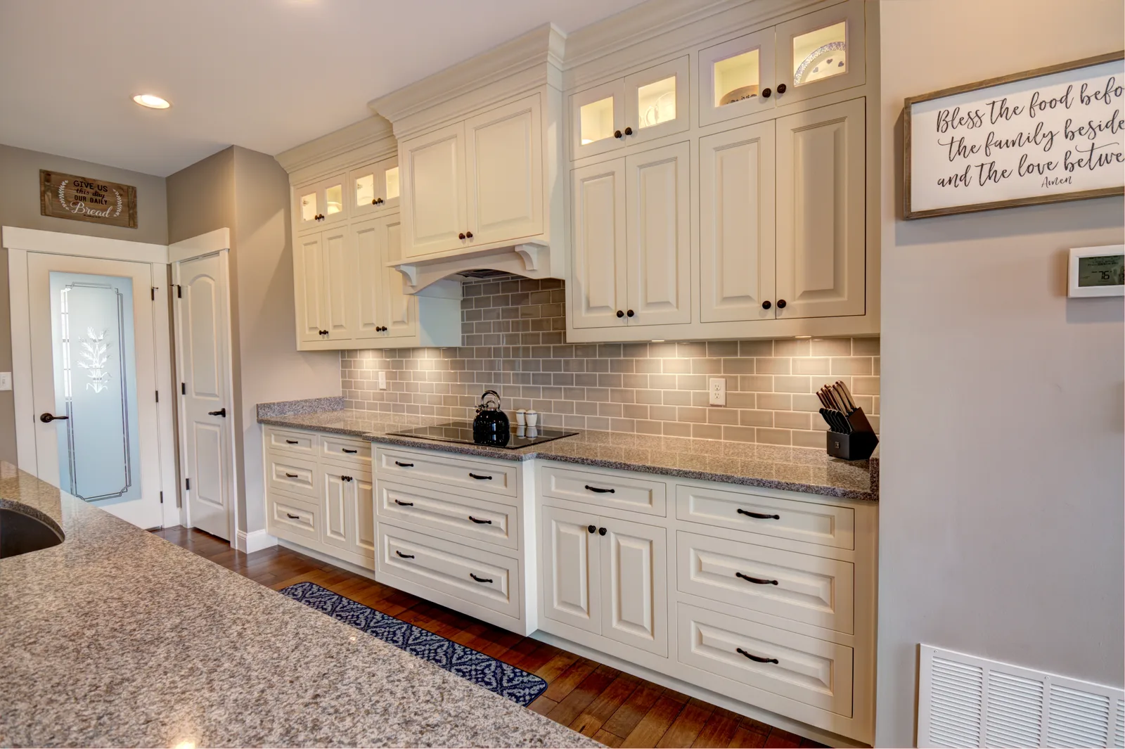 Cream kitchen with subway-tile backsplash and glass upper cabinets