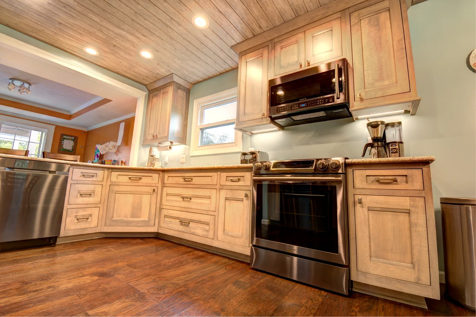 Driftwood-finish kitchen cabinetry with a plank ceiling