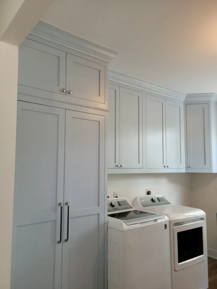 Light-blue laundry-room cabinetry above the machines