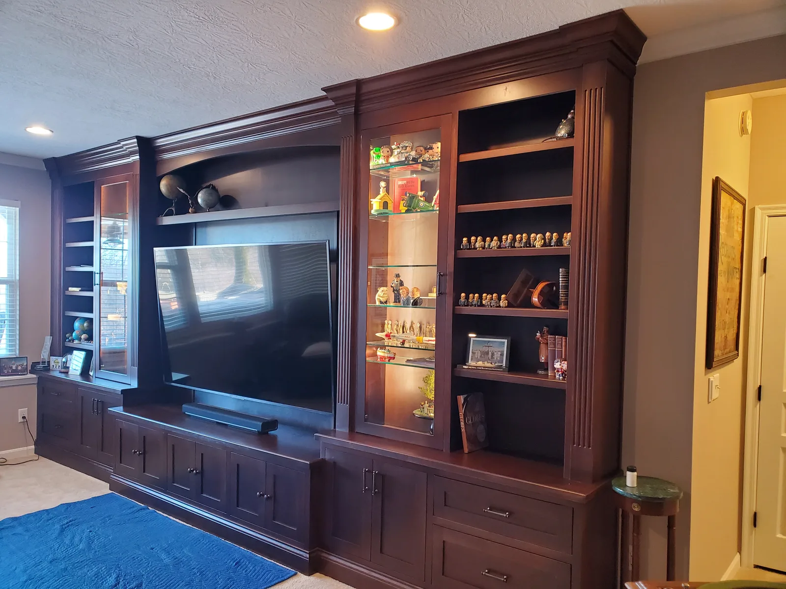 Cherry cabinetry with lit glass display shelving