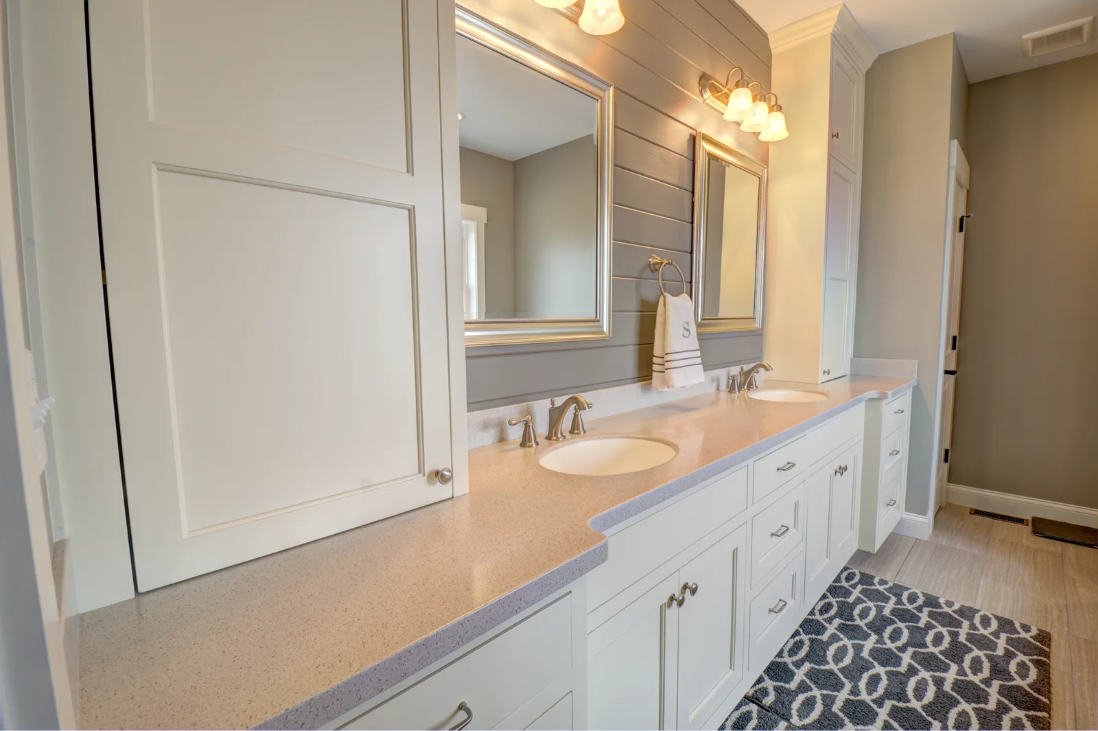 Custom white double bathroom vanity with shiplap accent wall and framed mirrors