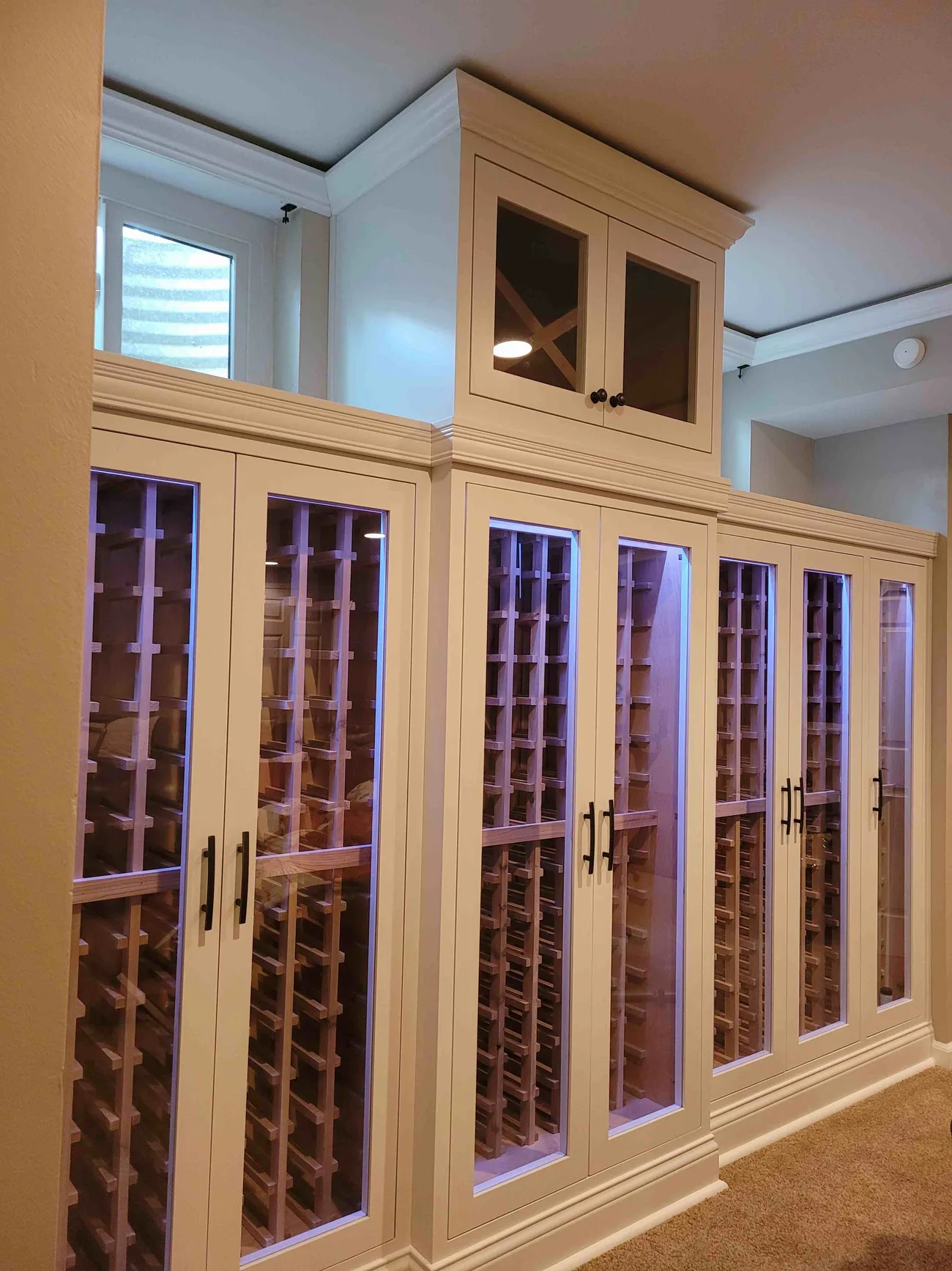 Custom white wine room with lit glass-front wine storage